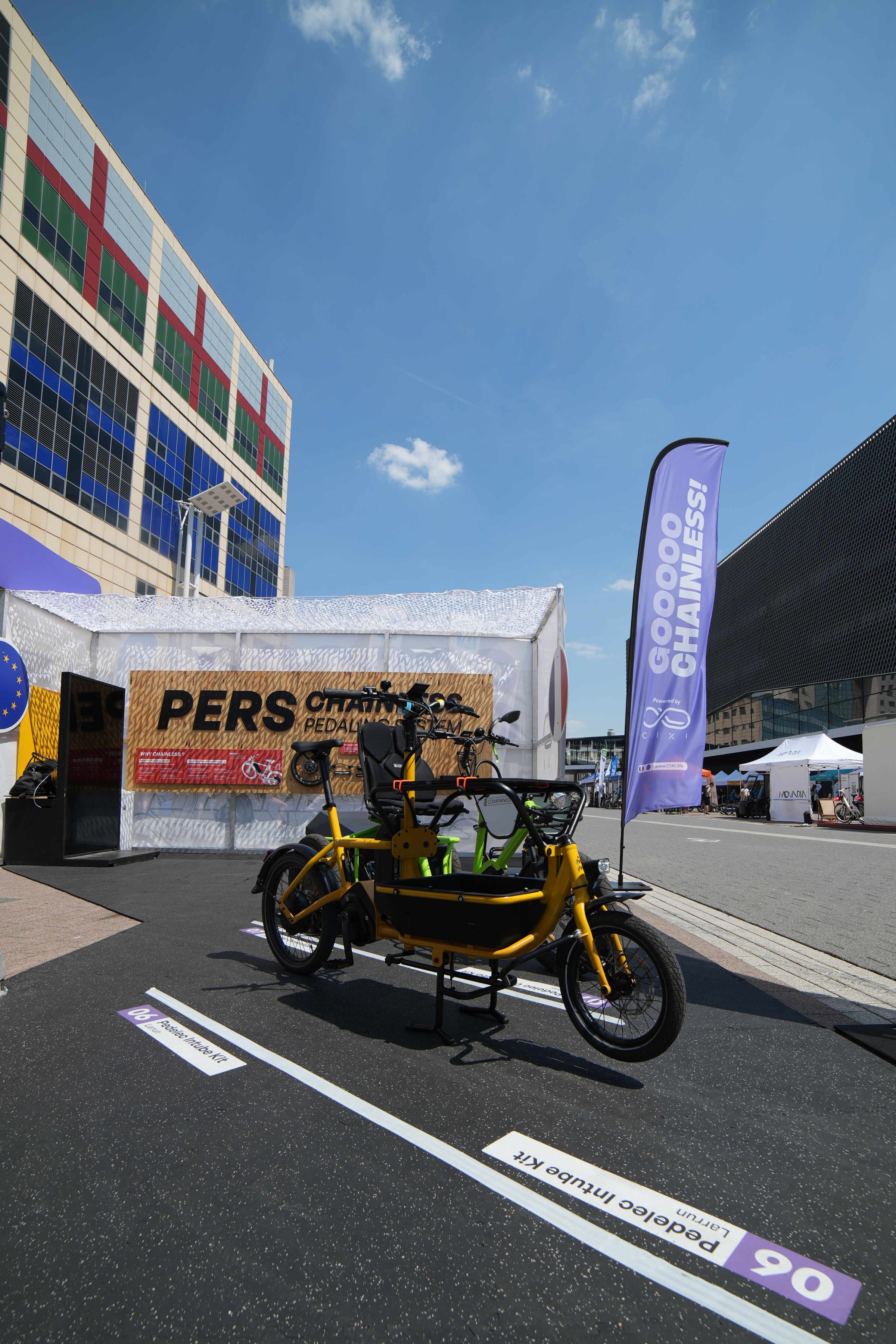 Vélo cargo équipé du pédalier PERS exposé sur un salon, devant le stand CIXI
